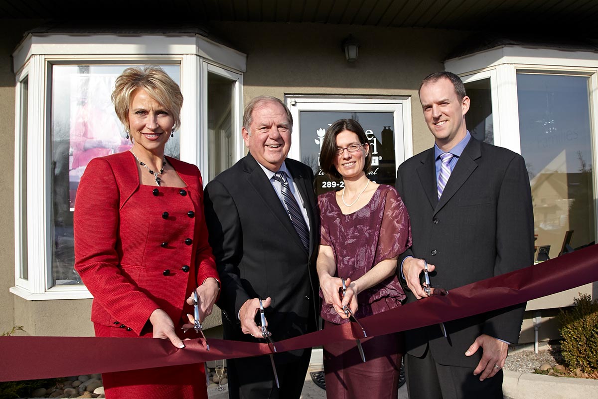 Home Instead franchise business ribbon cutting ceremony with four business people