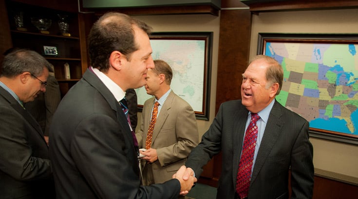 Businessmen greet each other inside office building