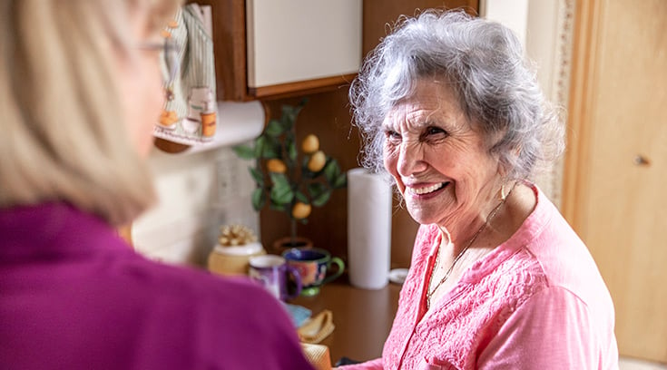 home instead senior woman smiling standing in kitchen
